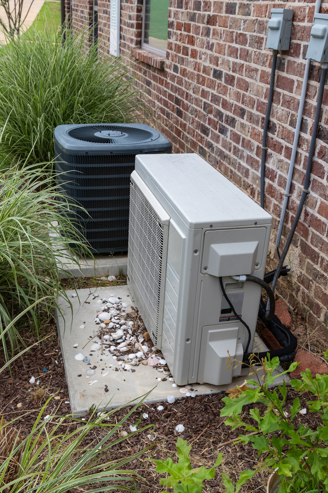 white and black air duct machine next to a brick wall
